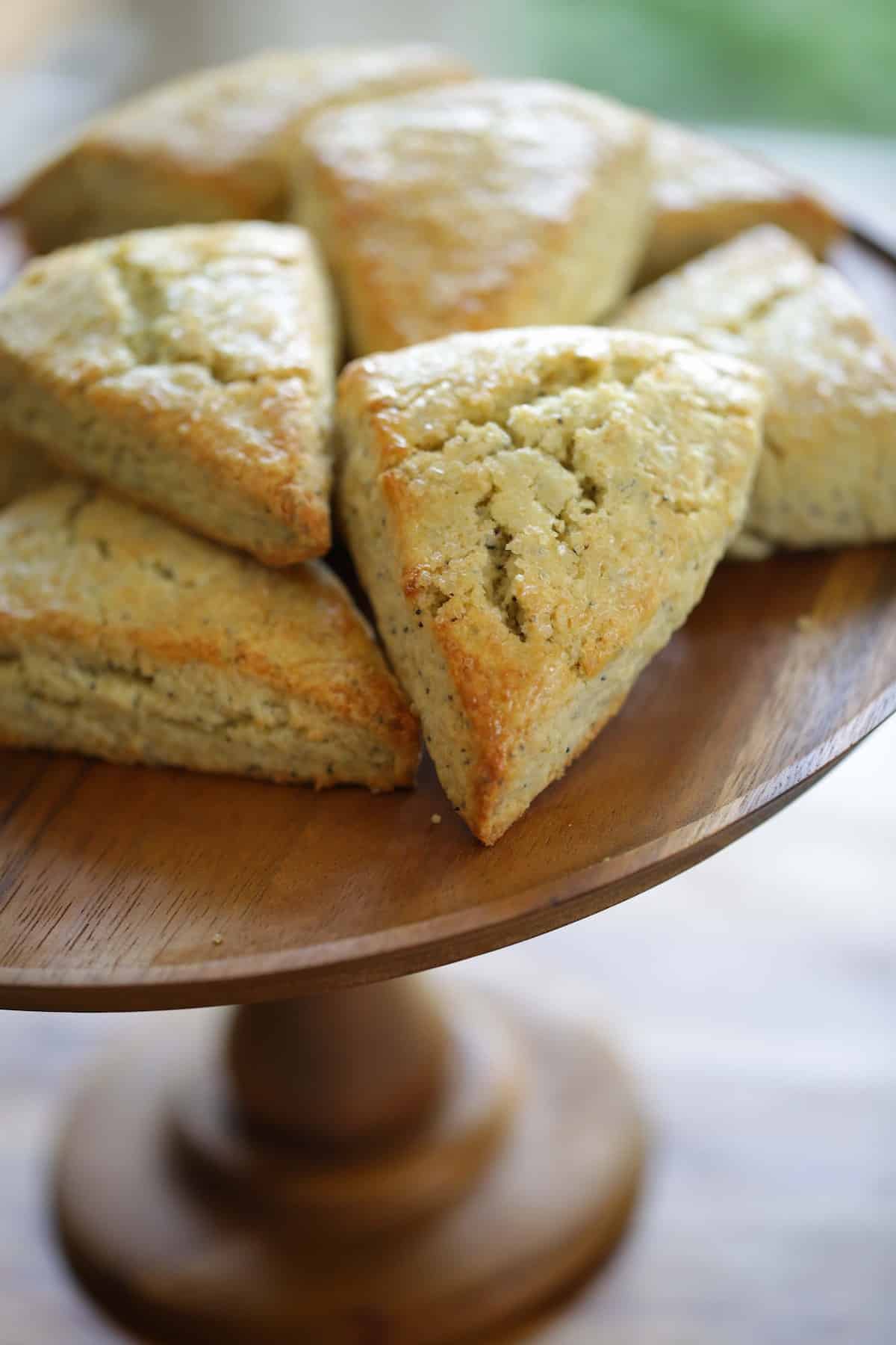 Lemon Poppy Seed Scones Piled on a Wooden Cake Stand