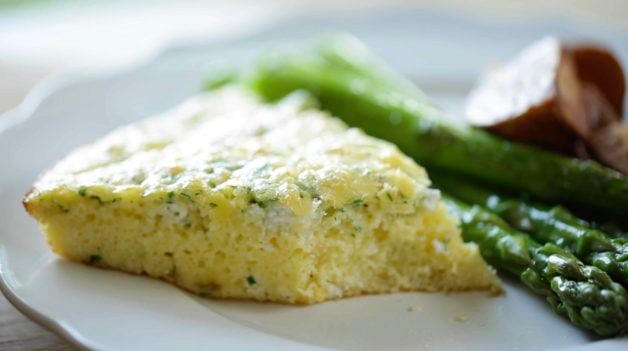 A slice of Egg Bake Casserole with a bite taken out to show the texture