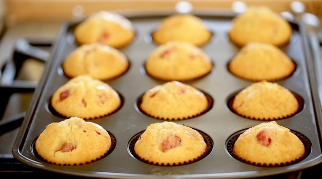 A tin of freshly baked Strawberry Muffins on a Cooktop cooling