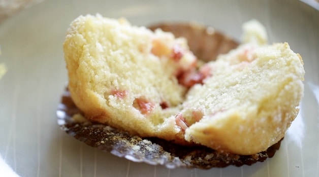 Strawberry Muffin sliced in half showing the light texture and baked strawberries inside
