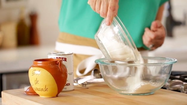 Adding flour to a mixing bowl