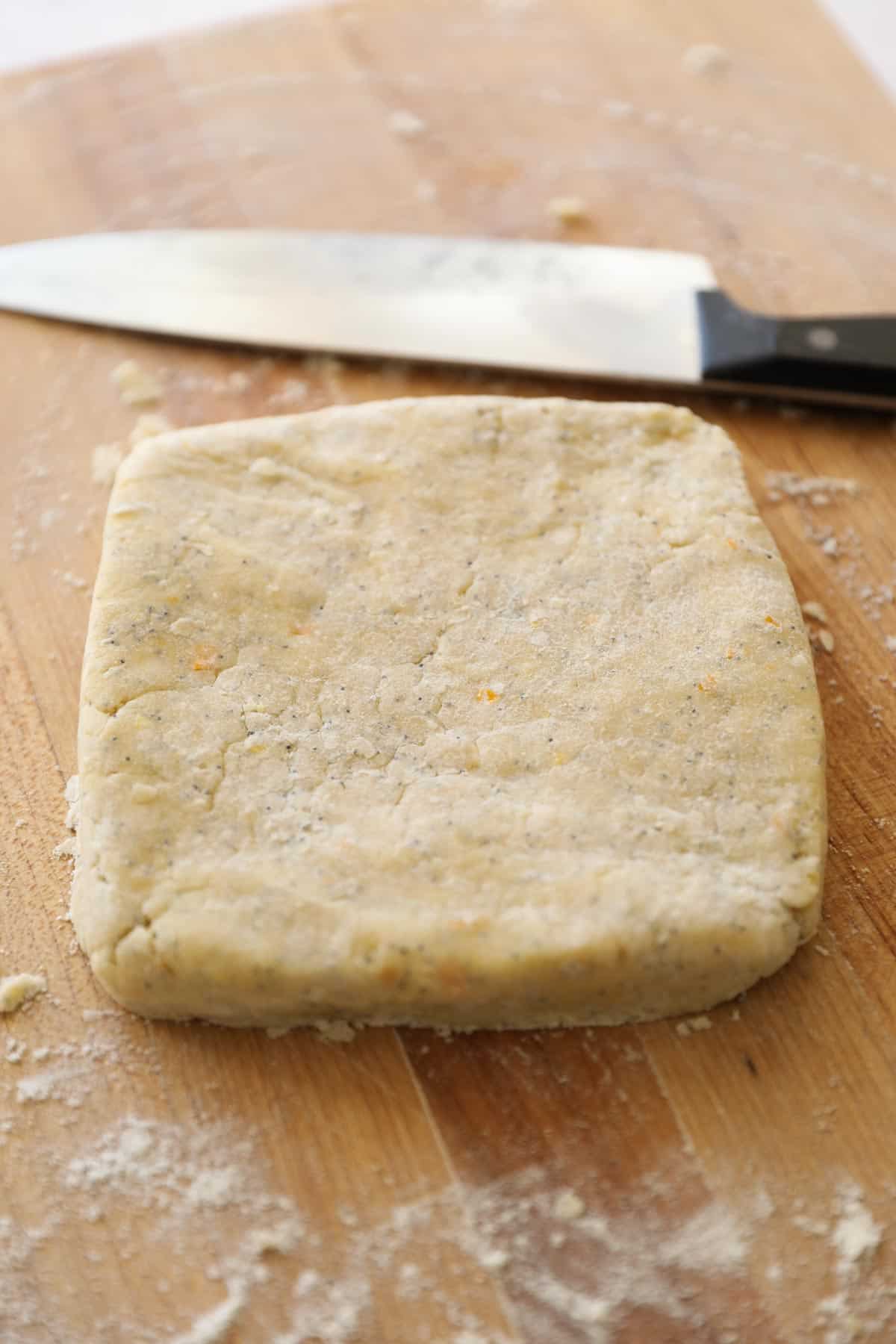 scone dough on a cutting board shaped into a sqaure