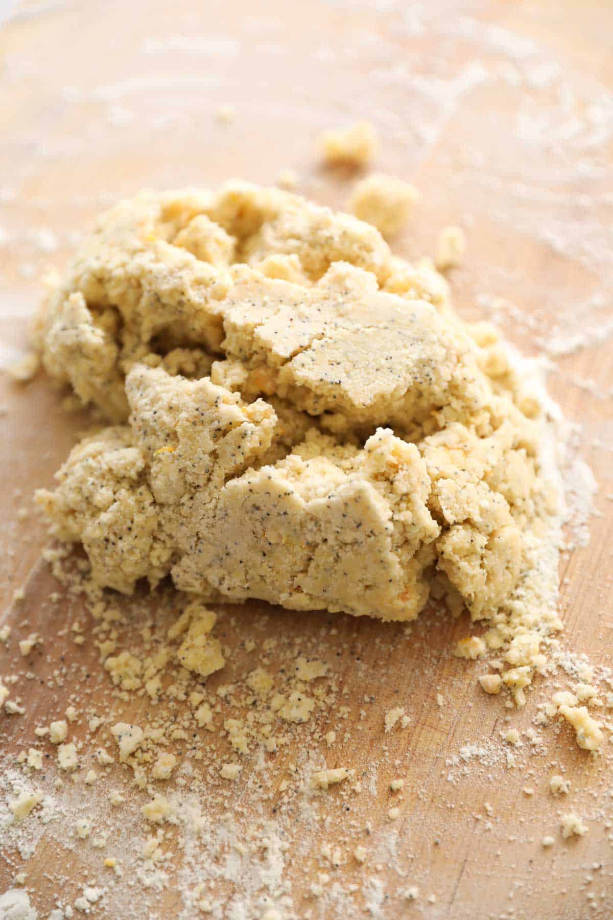 crumbly poppy seed scone dough piled in a mound on a floured surface