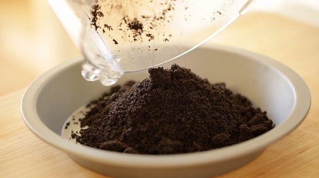 Mound of chocolate wafer crumbs for pie crust in pie tin