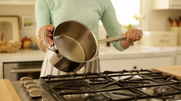 a person showing the bottom of a sauce pot