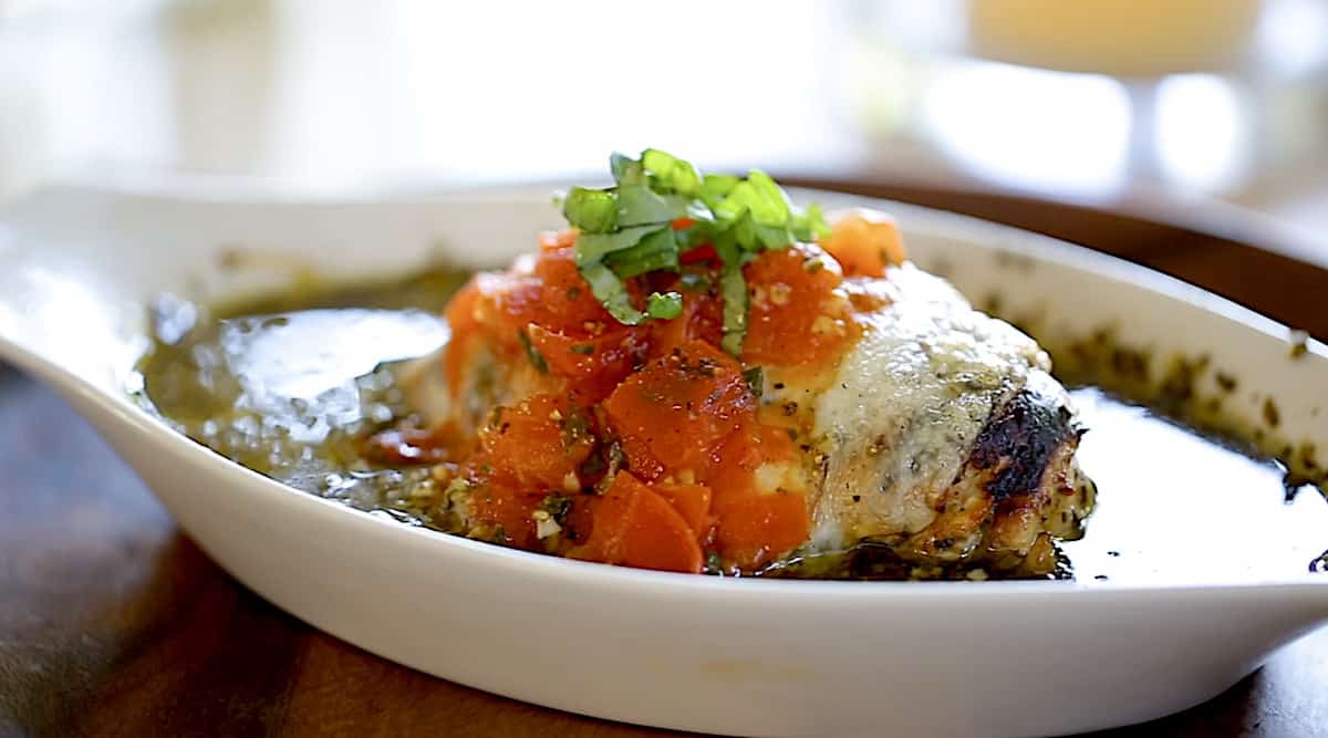 a pesto chicken bake with tomato sauce in a gratin dish