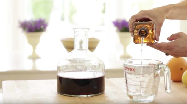 pouring cointreau into a Pyrex pitcher for an Easy Sangria Recipe