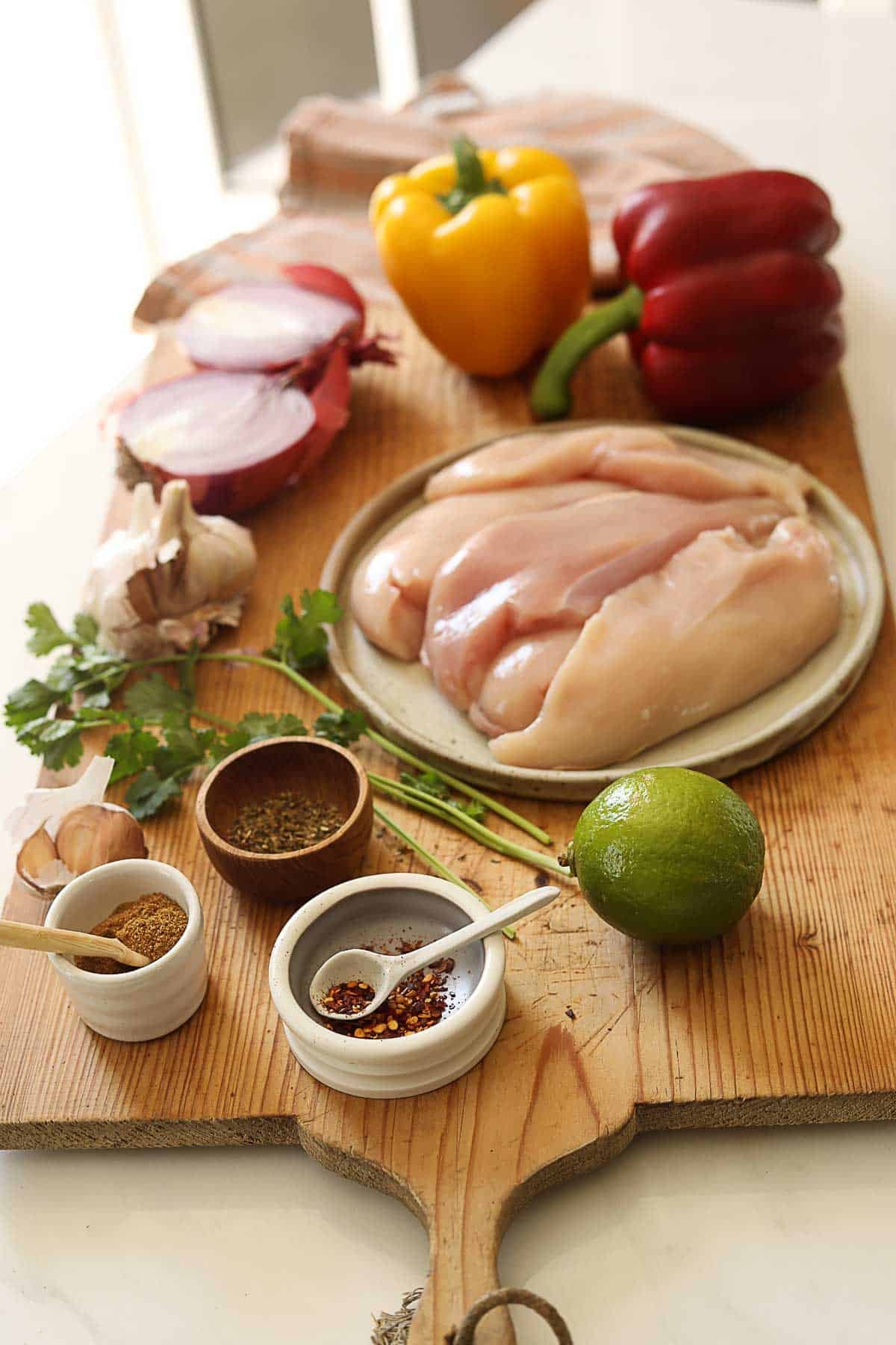 Ingredients laid out on a counter for making chicken fajitas.