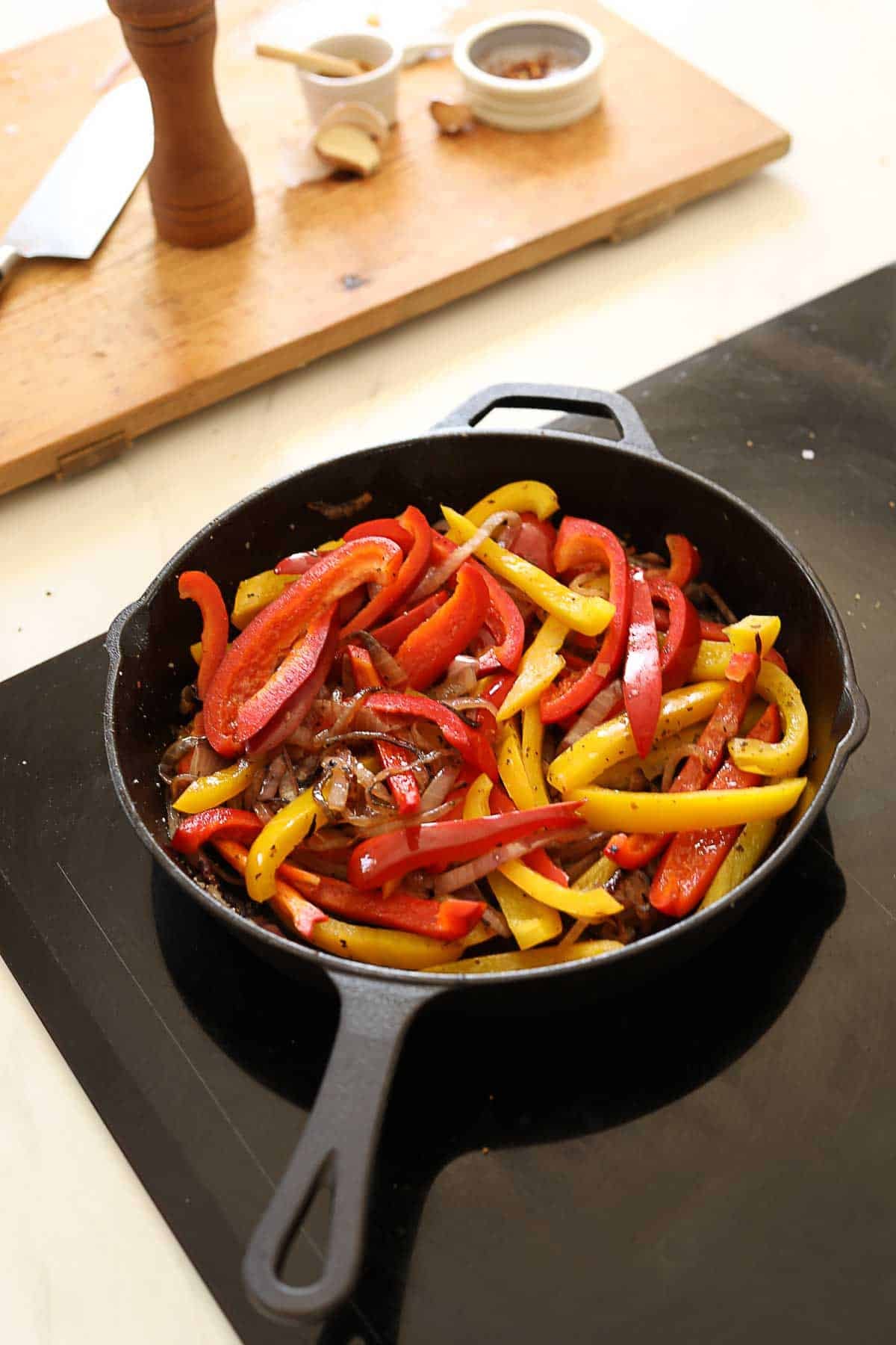 Sliced peppers and onions in a pan.
