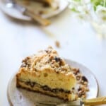 two slices of crumb cake on plates with forks