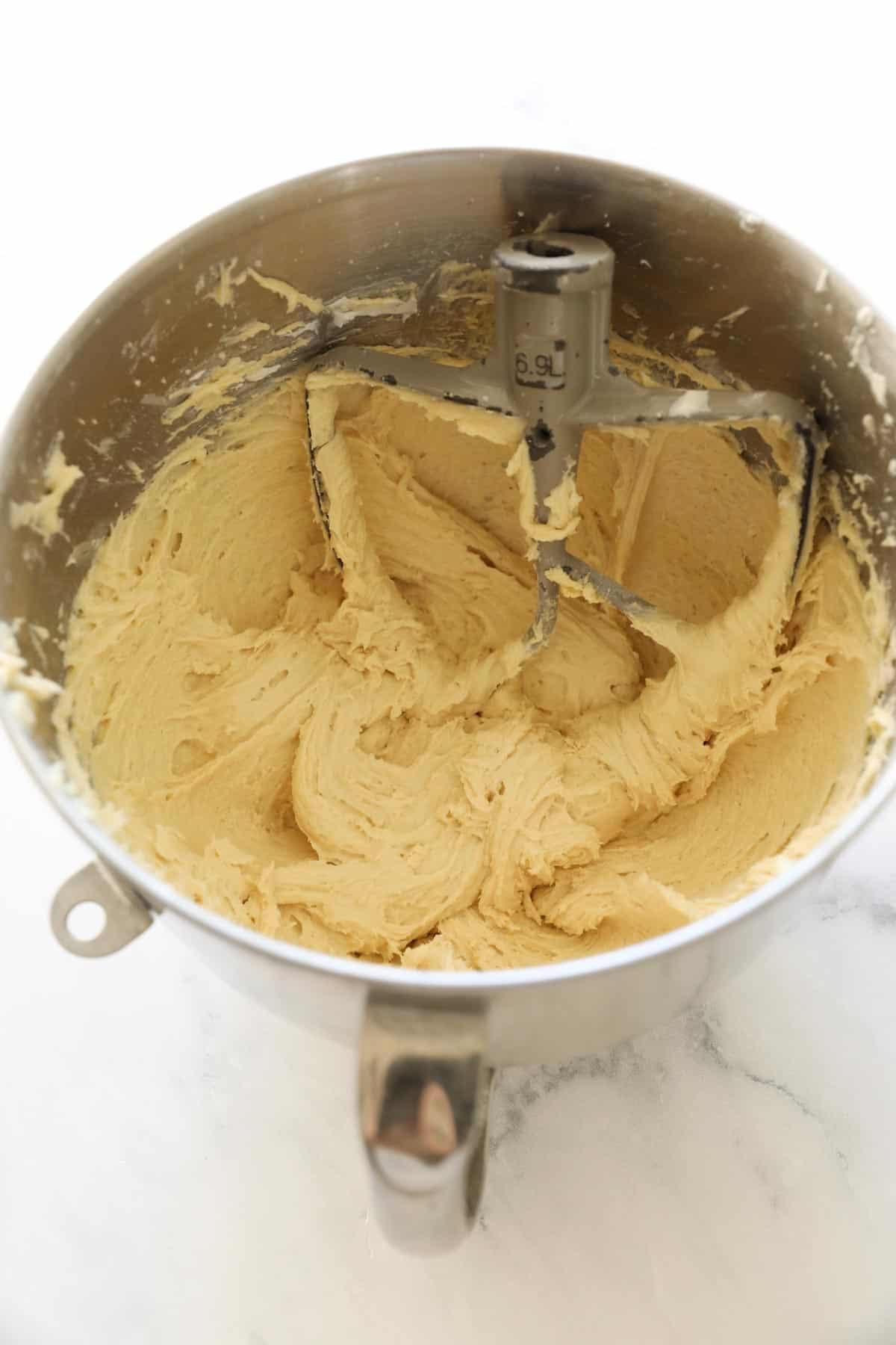 cake batter in a mixing bowl with paddle attachment