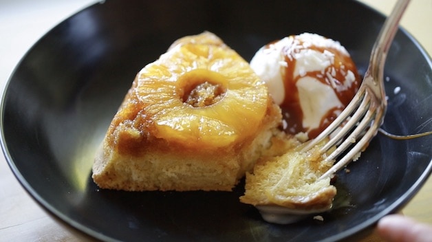 Slice of Cake with Ice Cream and Caramel Sauce with a person\'s fork taking a bite