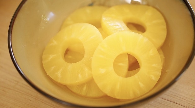Sliced pineapple rings in a beige bowl