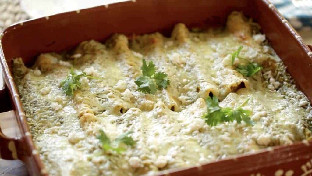 Enchiladas Suizas Recipe baked in a rectangular terra cotta casserole dish