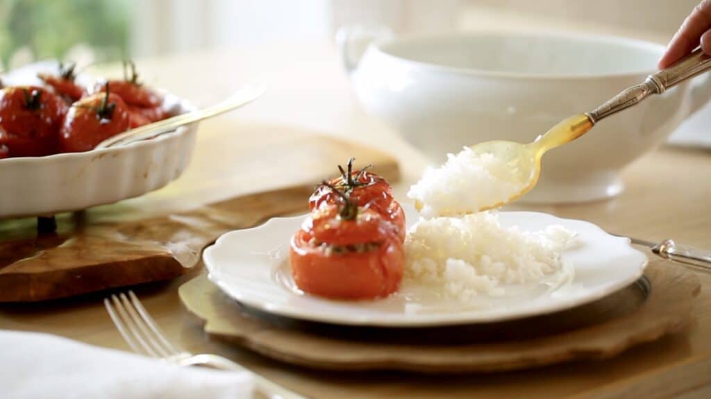 Tomates rellenos y arroz en plato blanco