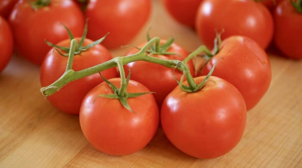 Tomaten an der Rebe auf einem Schneidebrett