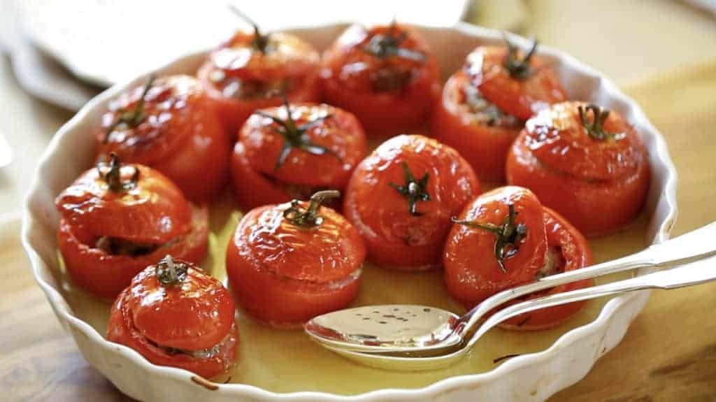 Stuffed tomatoes in a white serving dish 