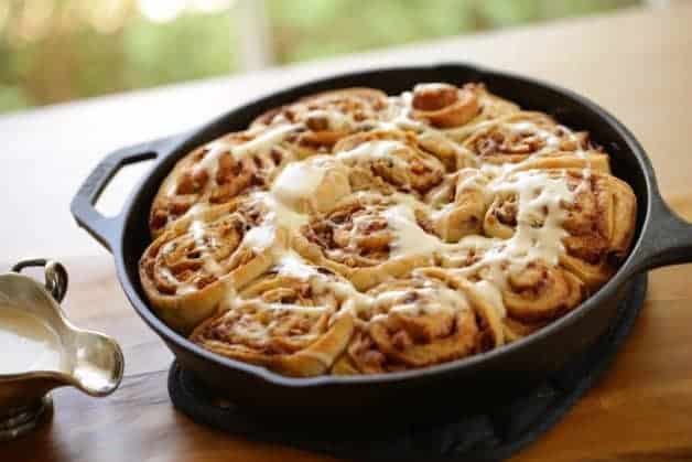 How to Make Cinnamon Rolls Recipe served in a cast iron skillet on a wood surface