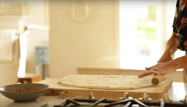 dough rolled out on a wood board for a How to Make Cinnamon Rolls Recipe