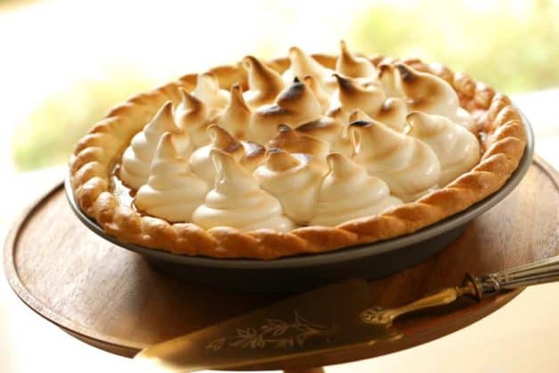 Pumpkin Pie with Marshmallow Topping on a wooden cake stand with a gold cake server