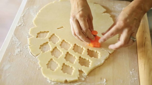 Cutting out pastry leaves on a wooden cutting board