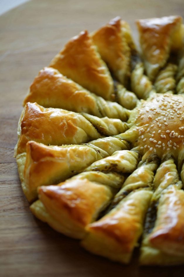 a Freshly baked Tarte au Soleil with pesto sauce on a cutting board