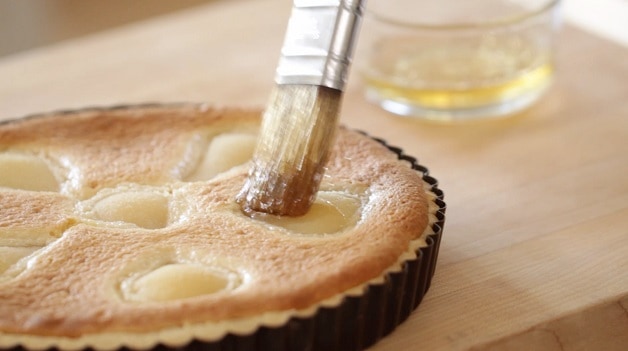 Brushing apple jelly on baked pears