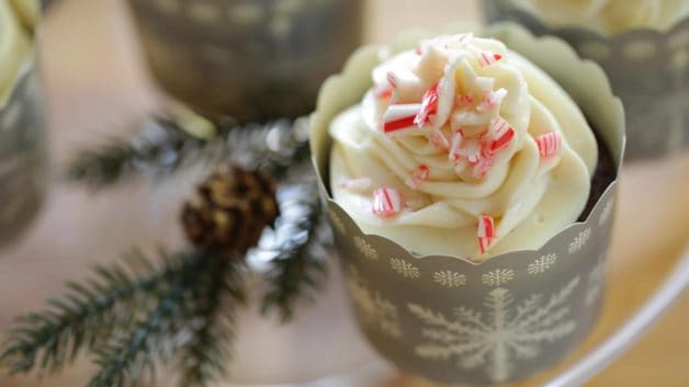 Chocolate Candy Cane Cupcakes with crushed candy canes and cream cheese frosting on cake stand
