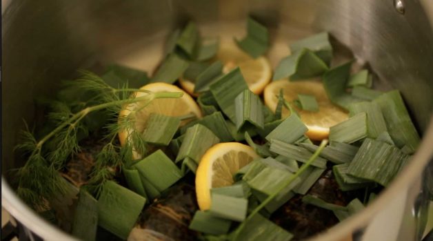 Chopped leeks, lemon and dill in a large pot for a Bouchée à la Reine with Lobster recipe