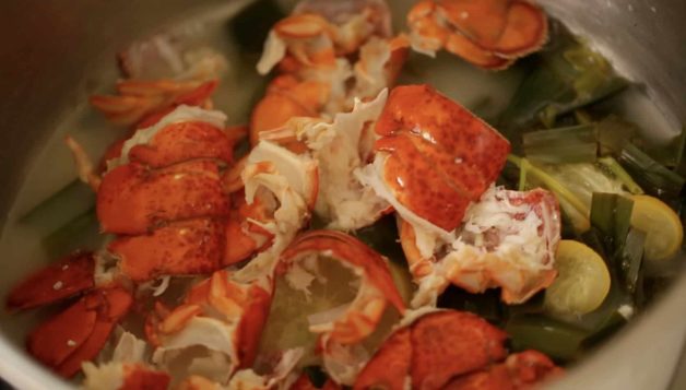 Cooked Lobster shells in a stock pot with vegetables for a Bouchée à la Reine with Lobster recipe