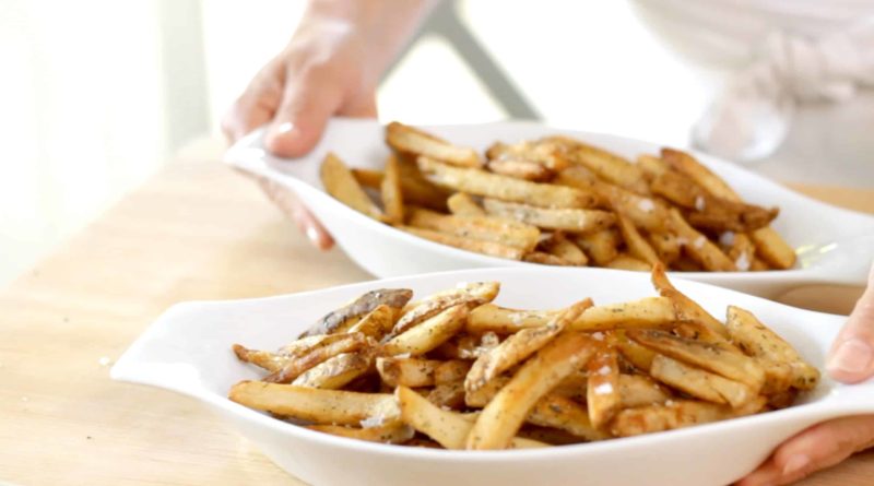 two white gratin dishes loaded with french fries 