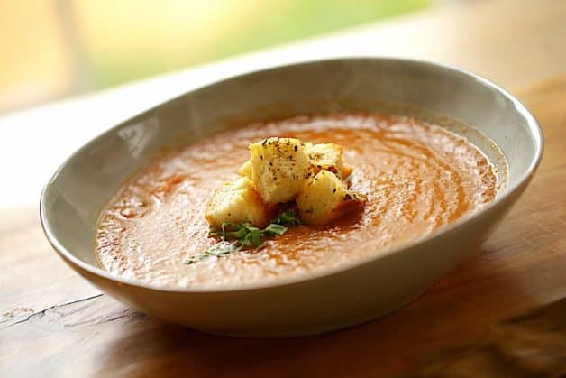 Close up shot of Roasted Tomato and Eggplant Soup in bowl with Croutons