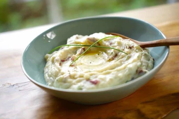 Sour Cream and Chive Mashed Potato Recipe in a blue bowl with wooden serving spoon