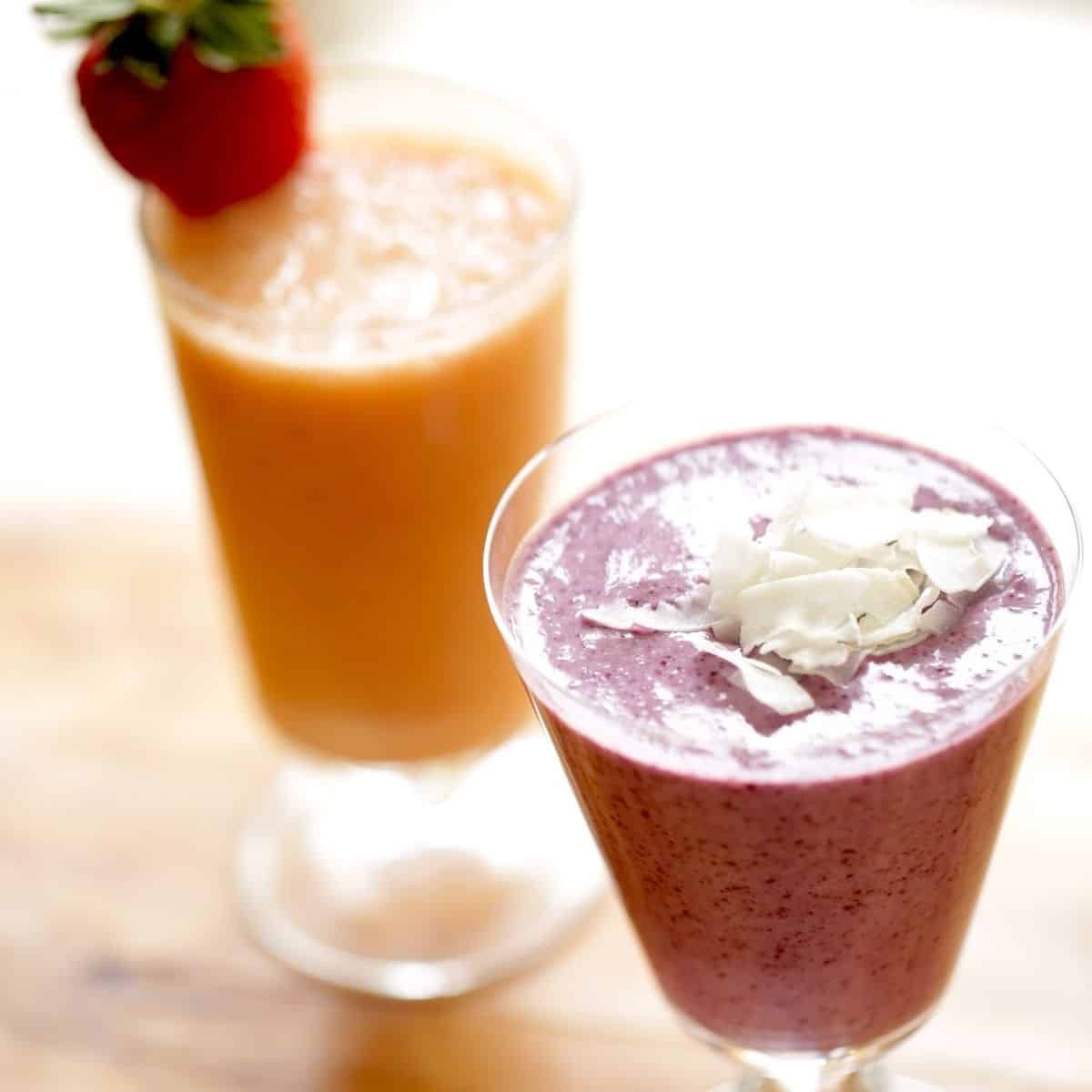 A Tropical Smoothie and a Blueberry Smoothie on a table