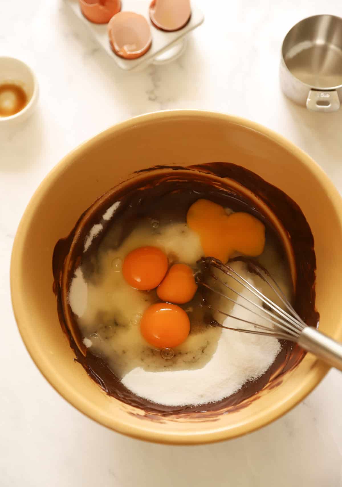 eggs, sugar, chocolate and butter in a bowl