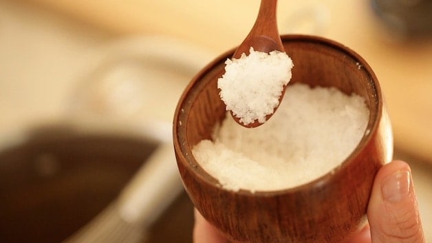 fleur de sel sea salt in a wooden pot with wooden spoon