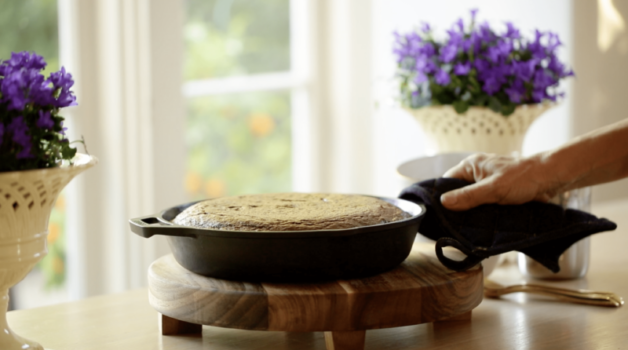 Warm Chocolate Skillet Cake in a cast-iron skillet served on a table on top of a wooden trivet