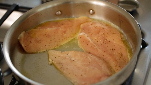 searing boneslles skinless chicken breasts in a skillet