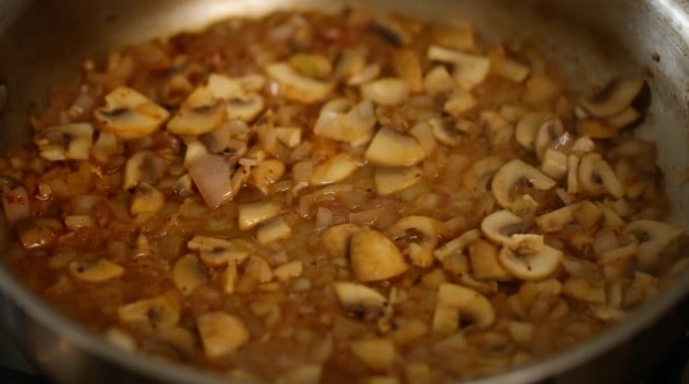 reducing wine and mushrooms with shallots in a skillet