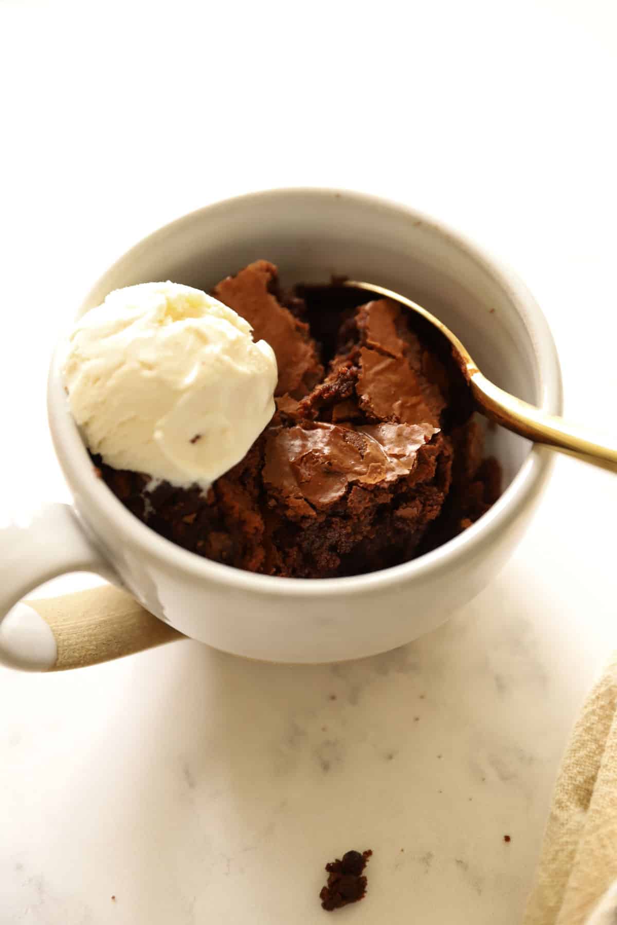 a pottery mug filled with brownie cake and vanilla ice cream 