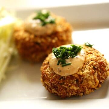Air Fryer Crab Cakes topped with remoulade sauce and fresh chives