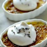 Lavender Honey Creme Brulees in a ramekin with whipped cream and lavender blossom garnishes