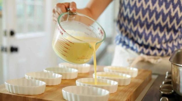 Pouring Creme Brulee custard into shallow scalloped ramekins