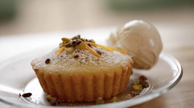 Pistachio Olive Oil Cakes with scoop of vanilla Ice Cream resting on a plate