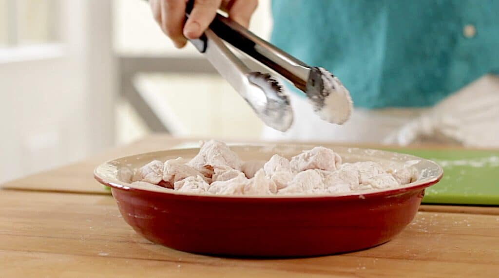 Dusting chicken breast pieces with cornstarch