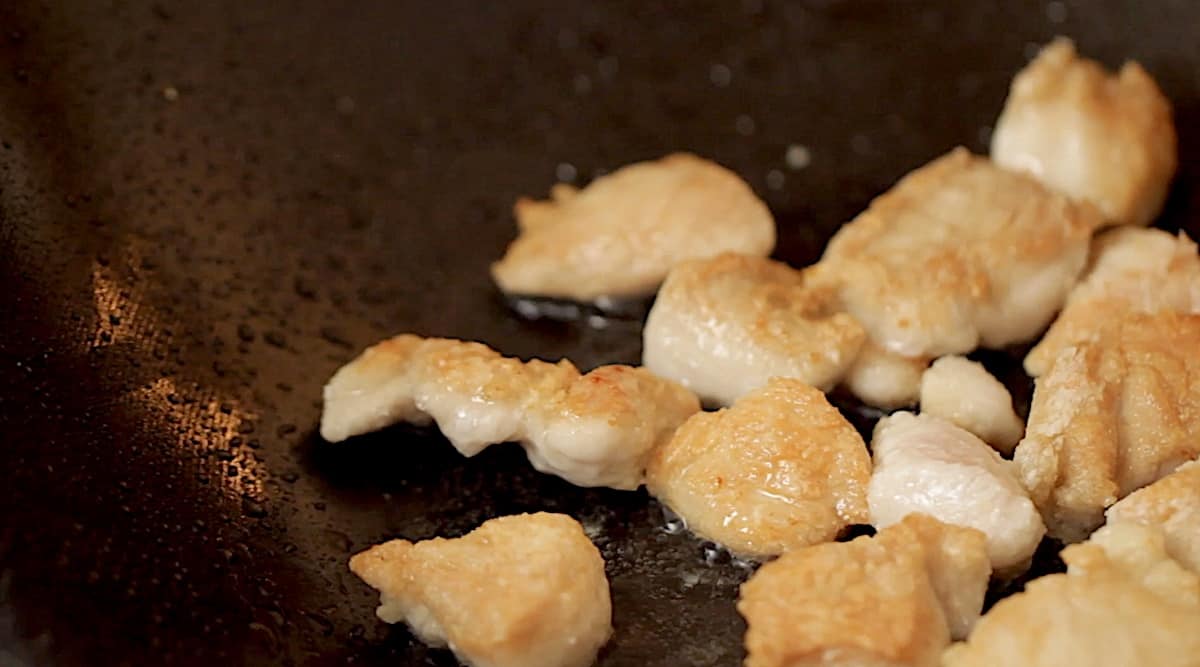 Frying chicken in a wok pan