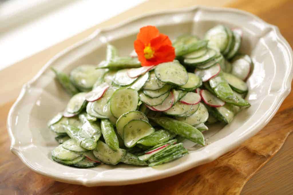 Creamy Cucumber Dill Salad Recipe topped with a nasturtium flower garnish 