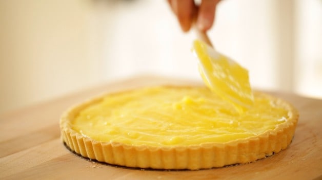 spreading lemon curd into a baked tart shell