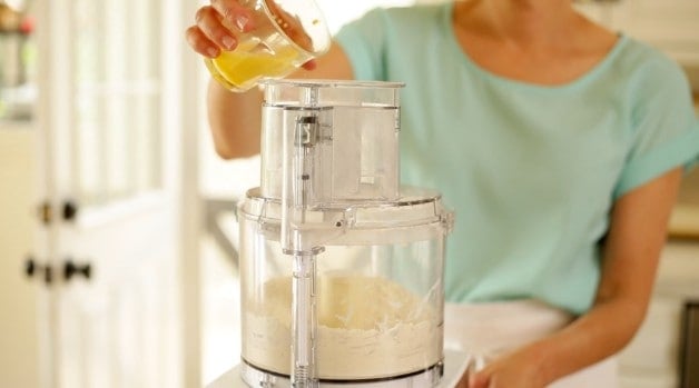 Beaten egg mixture being poured into a food processor