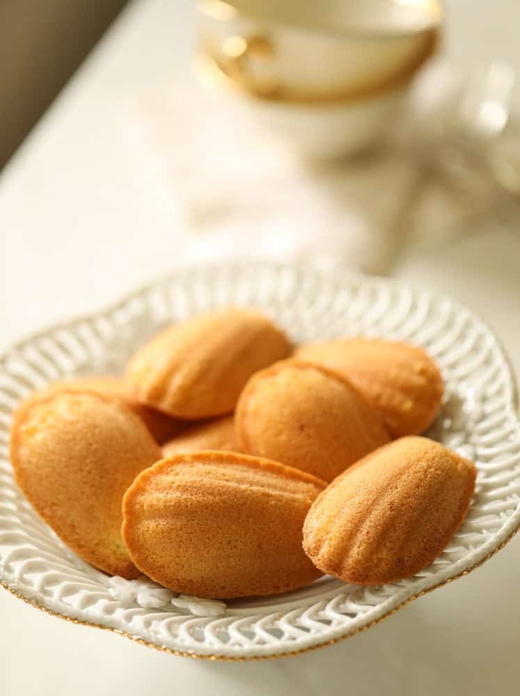 Baked Madeleines in a white dish, showing shell pattern